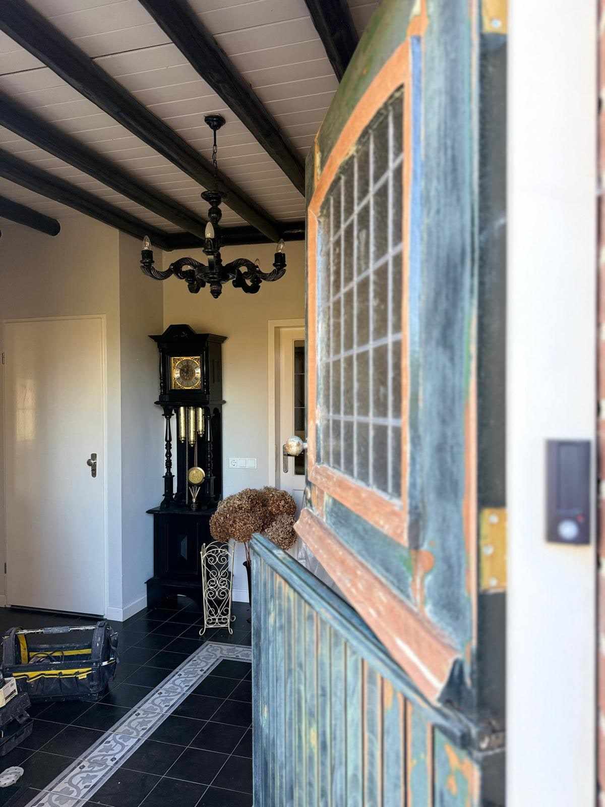Detail van een verweerde houten deur met loszittende verflagen en zichtbare houtnerf