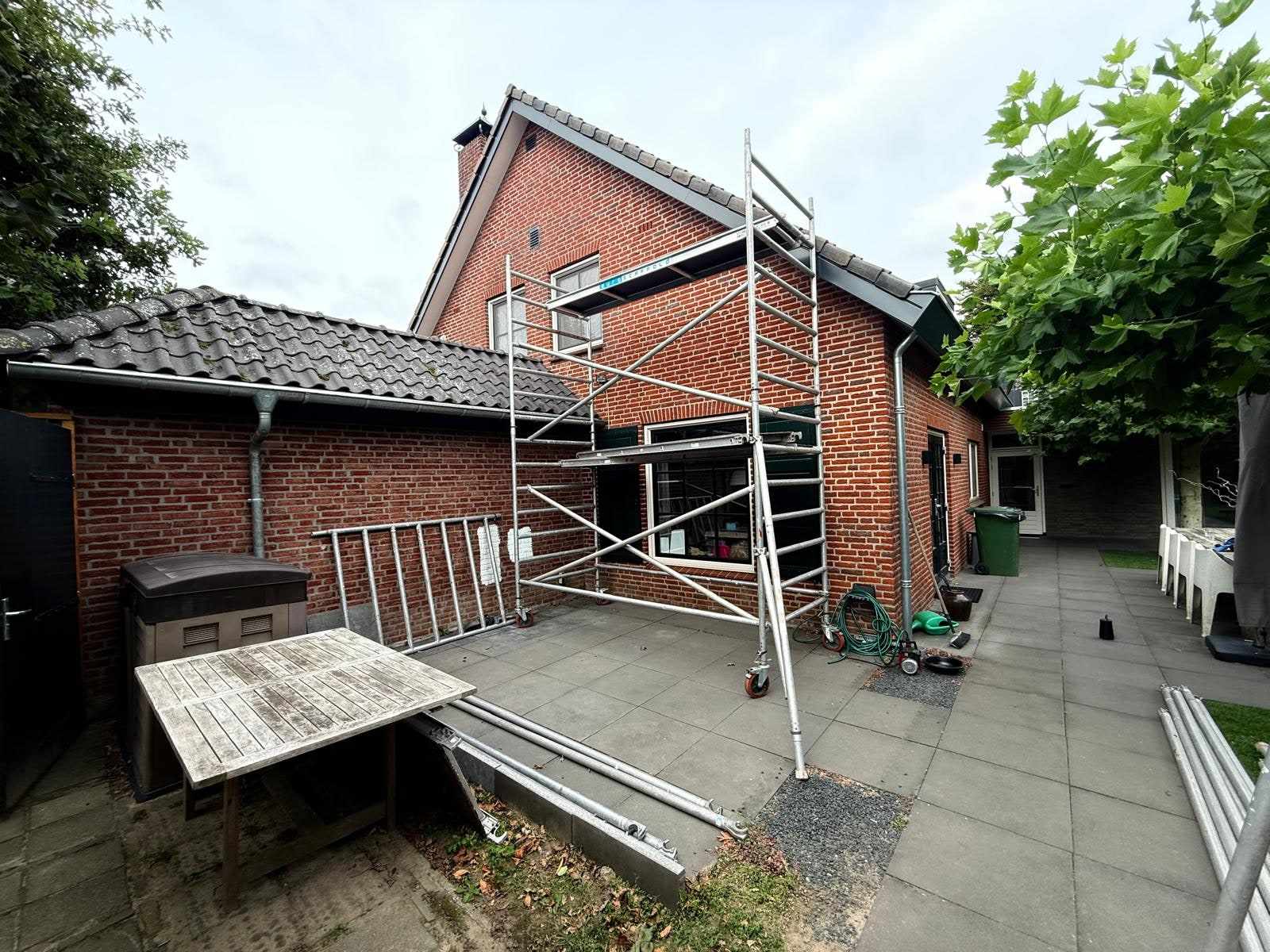 Rolsteiger op het achterterras tegen de nog rode bakstenen achtergevel