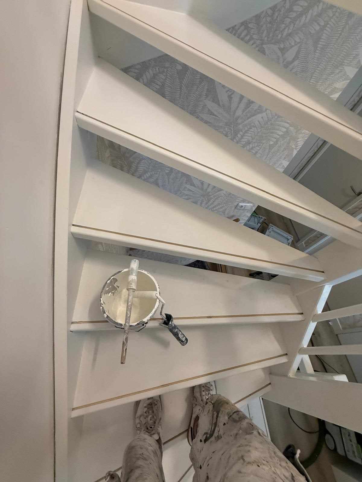 Verfemmer op een trede terwijl de trap in de witte lak wordt gezet