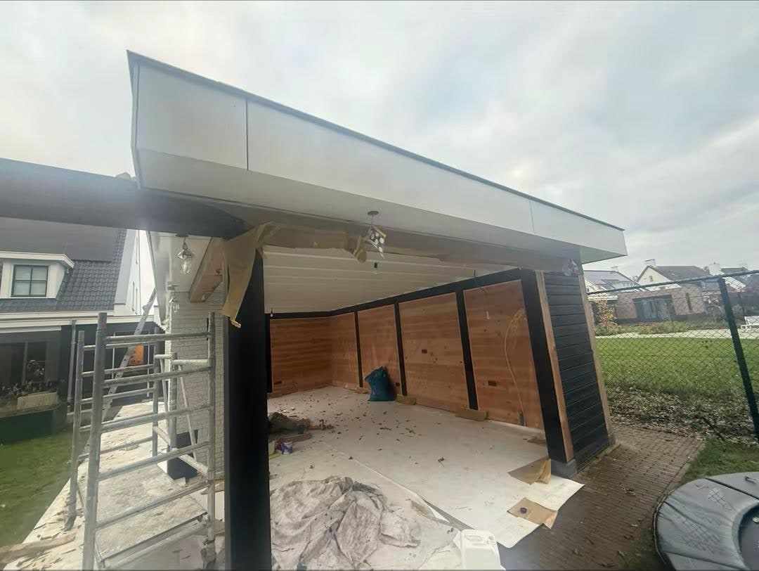 Overkapping met witte dakrand en rolsteiger eronder, uitkijkend over het weiland