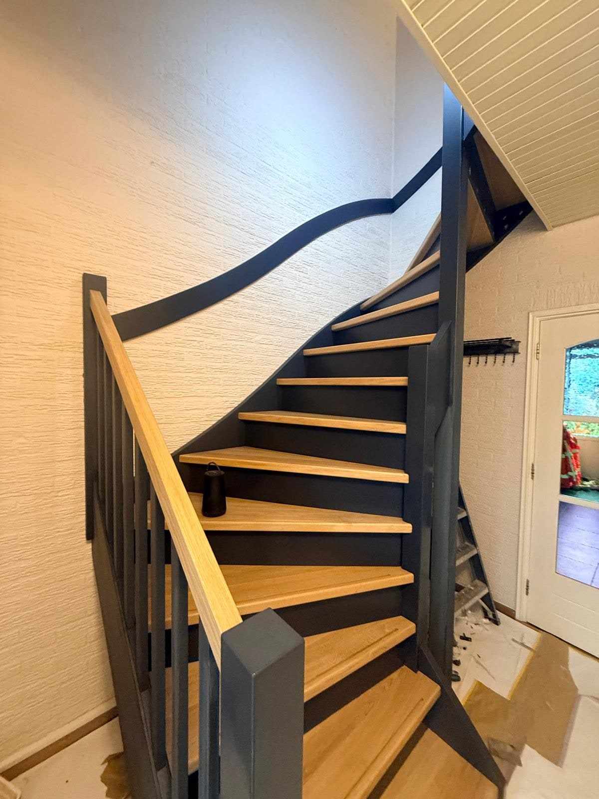 Trap in de hal met afdekzeil op de vloer tijdens het lakken van de treden