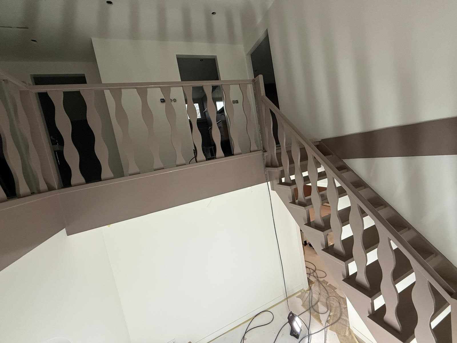 Geschilderde trapbalustrade met gedraaide spijlen naast de witte wanden