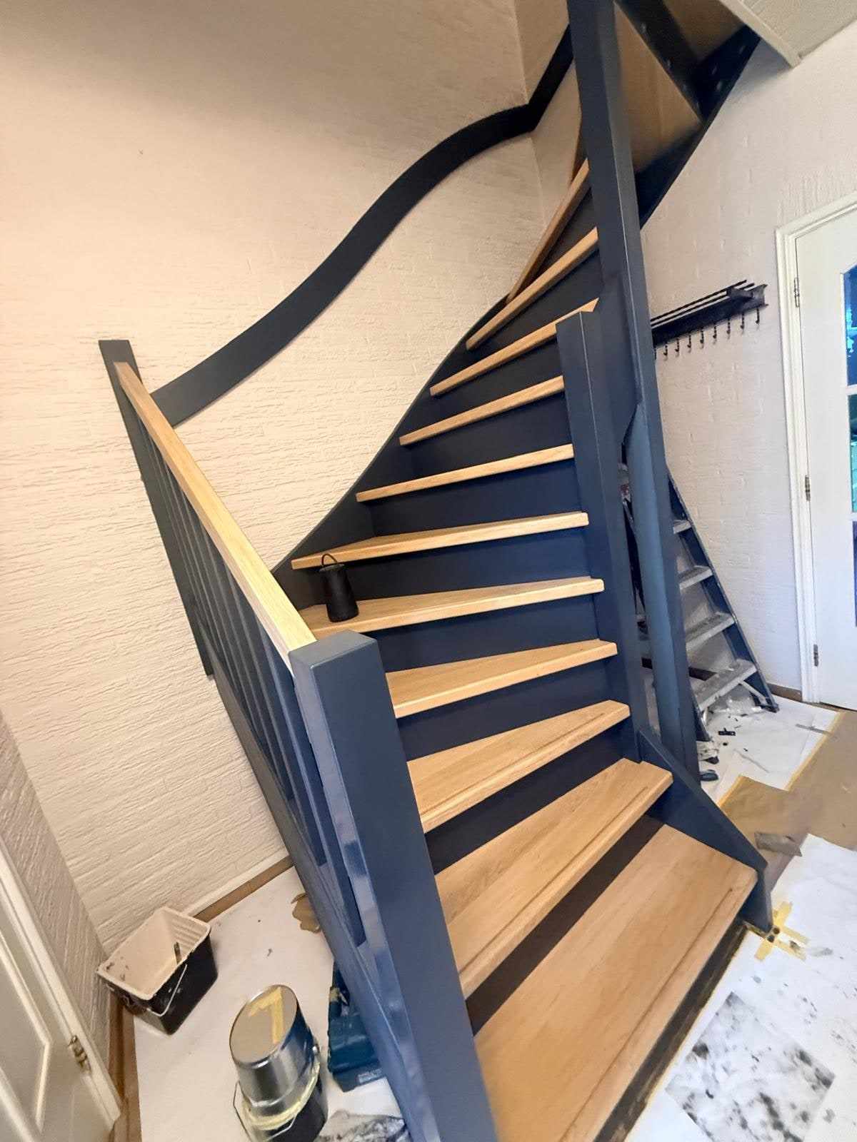 Trap met balustrade en afgedekte vloer, verfblik onderaan de trap
