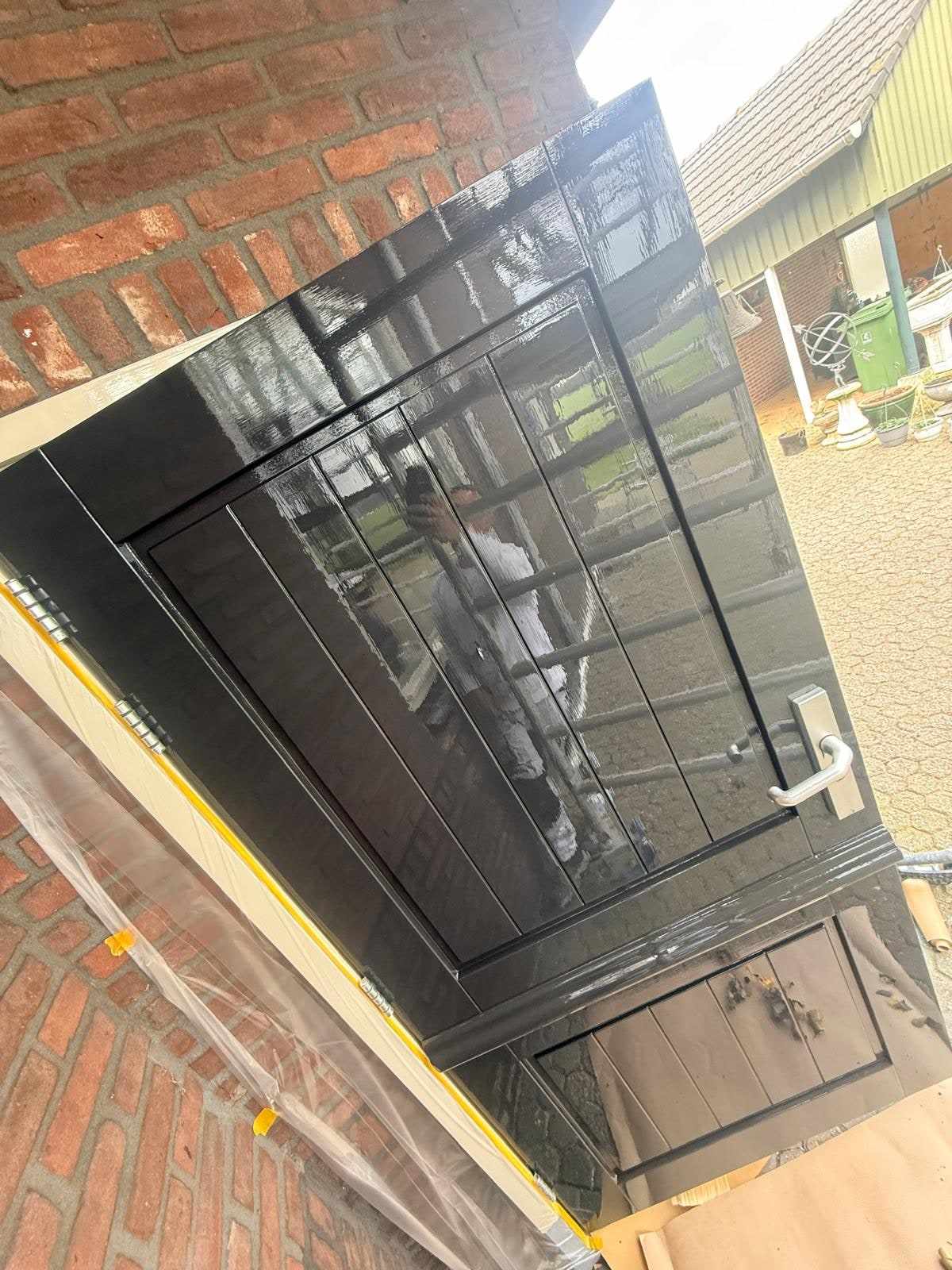 Hoogglans zwart gelakte deur die het licht en de omgeving spiegelt