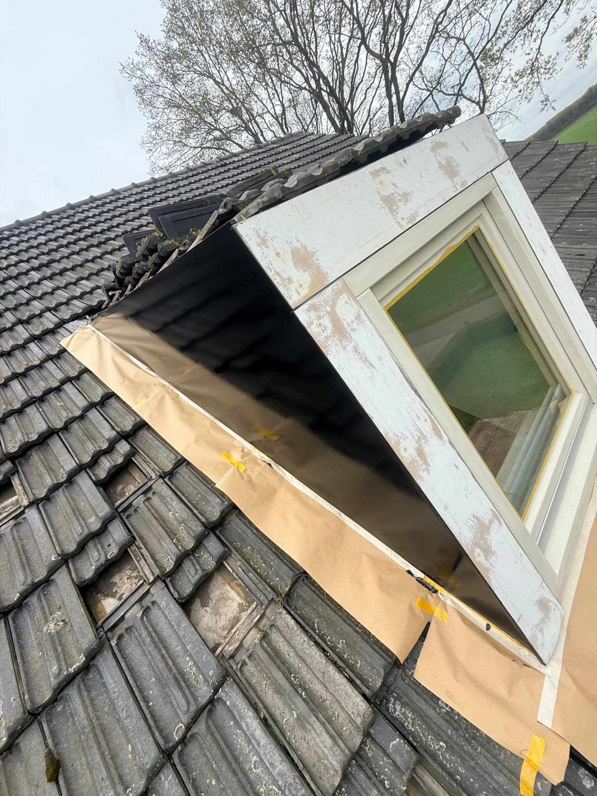 Dakkapel halverwege het werk: één zijwang al hoogglans zwart, de voorzijde nog kaal geschuurd